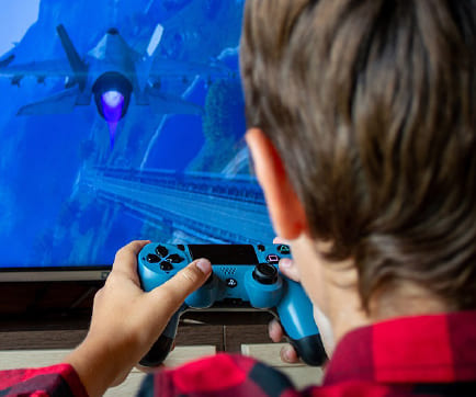 A boy playing a video game on a large screen